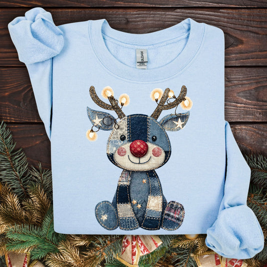 Light blue Gildan sweatshirt with a printed faux denim patchwork baby Rudolph wearing twinkling lights.