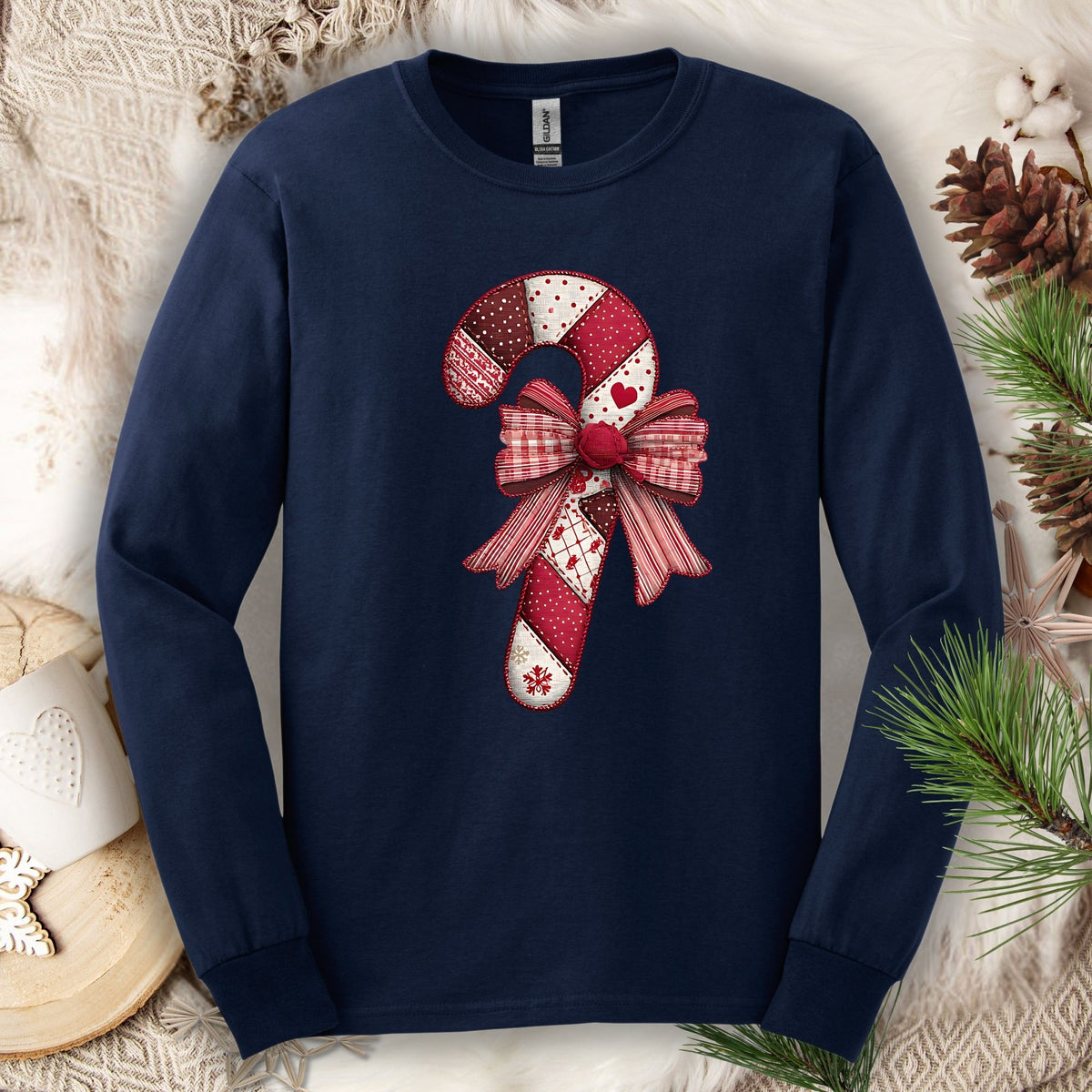 Navy long sleeve tee with a vintage faux patchwork candy cane and red bow design.