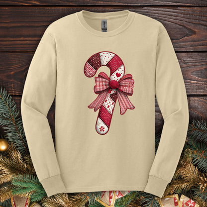 Sand Gildan long sleeve tee with a faux patchwork candy cane and red bow design.