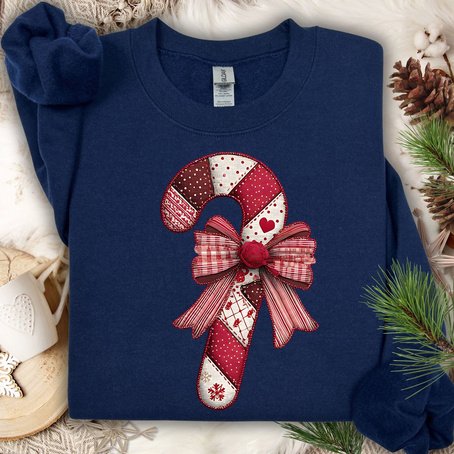 Navy Gildan sweatshirt with a vintage faux patchwork candy cane and red bow design.