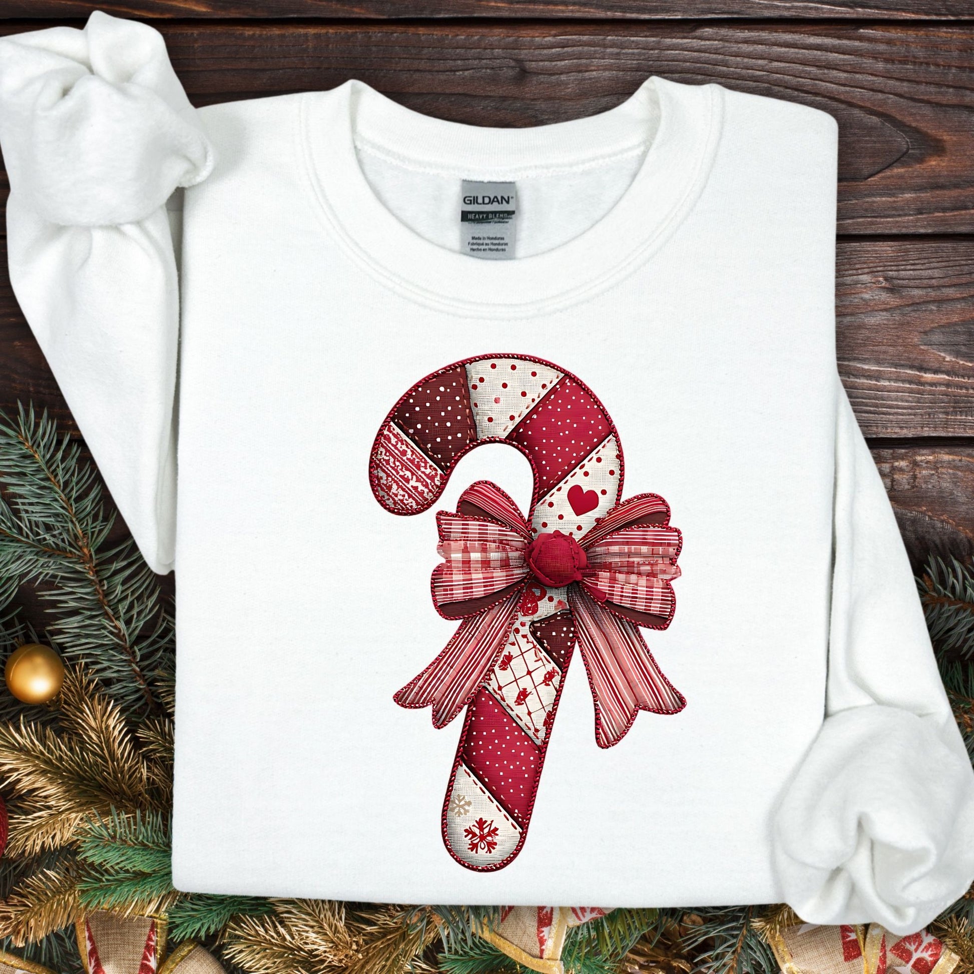 White Gildan sweatshirt with a vintage faux patchwork candy cane and red bow design.