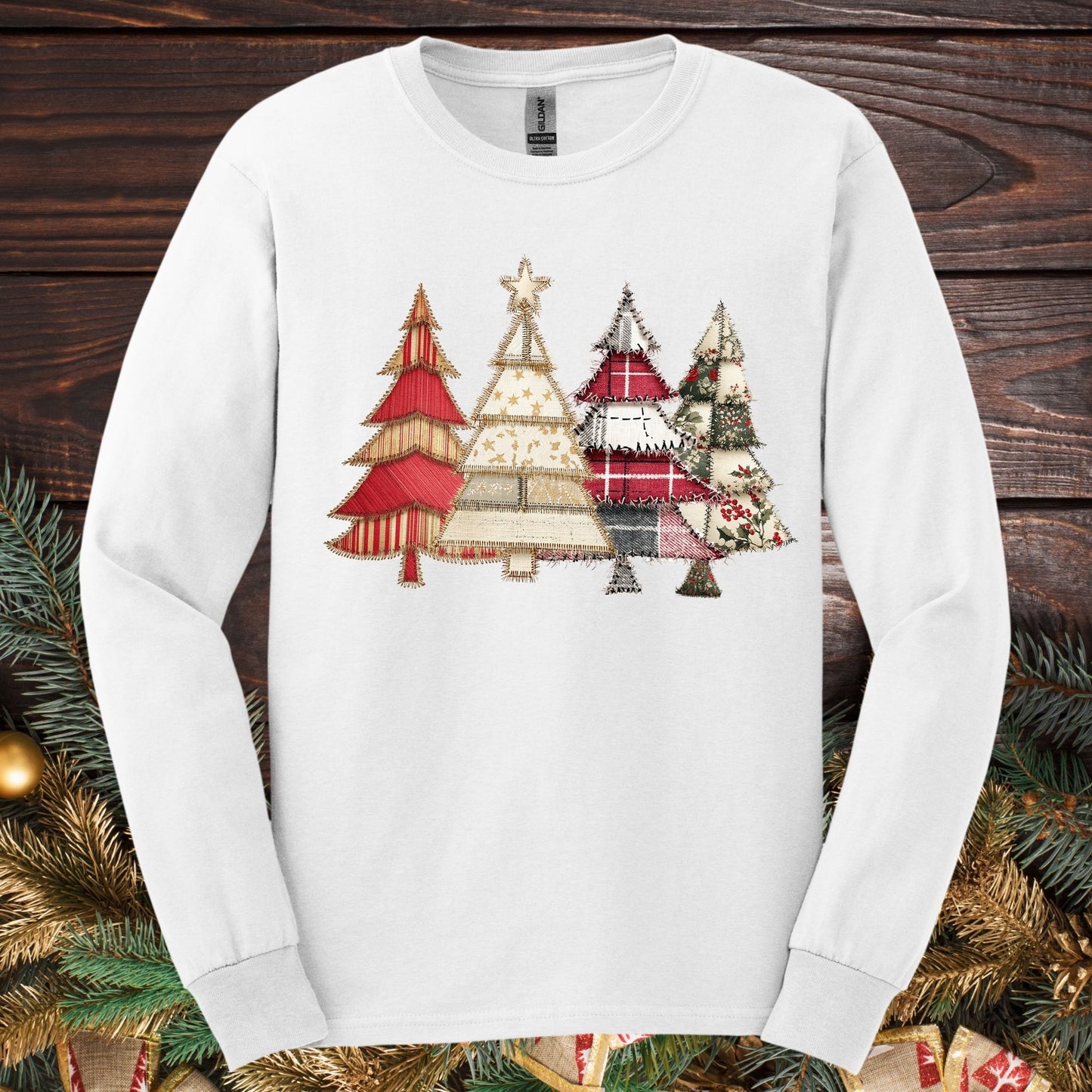 White long sleeve tee with a rustic faux patchwork Christmas tree design in reds, greens, and neutrals.