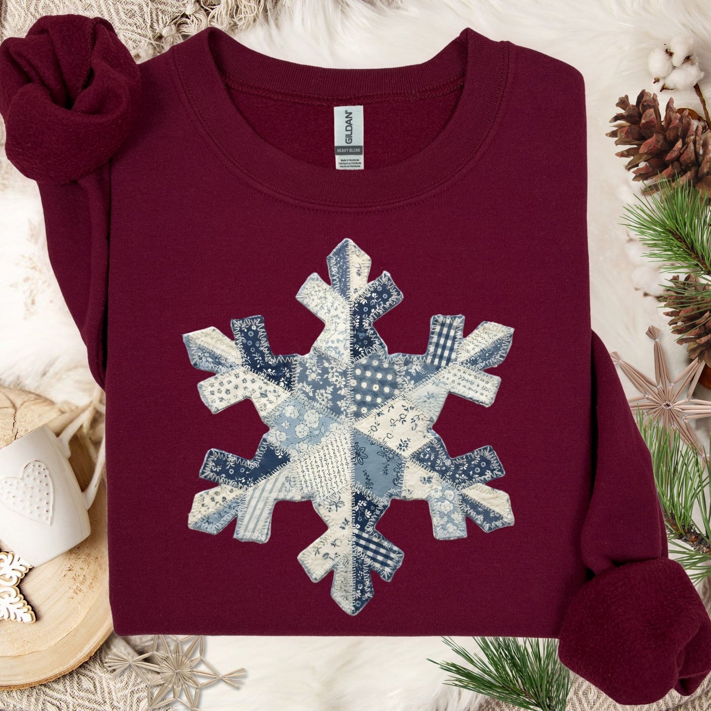 Maroon heavy blend sweatshirt with a large faux patchwork blue and white snowflake design.