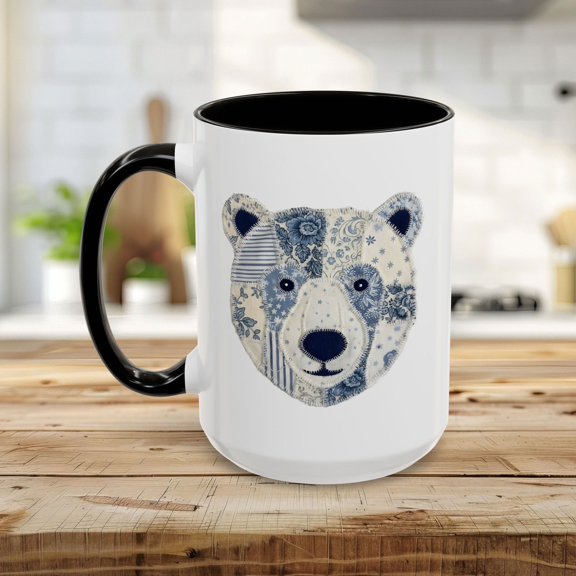 White ceramic mug with black rim and handle, featuring a blue and white faux patchwork winter bear face.