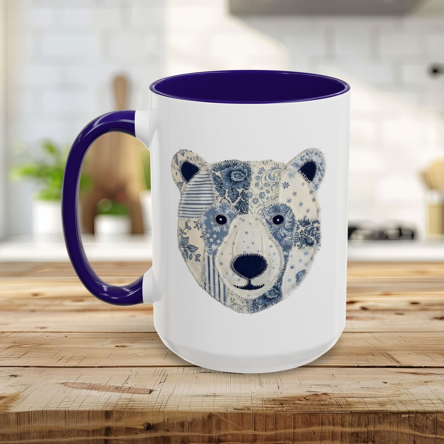 White ceramic mug with blue faux patchwork winter bear design, blue rim and handle.