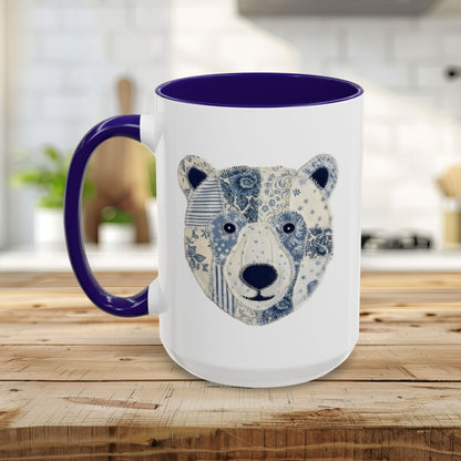 White ceramic mug with blue faux patchwork winter bear design, blue rim and handle.