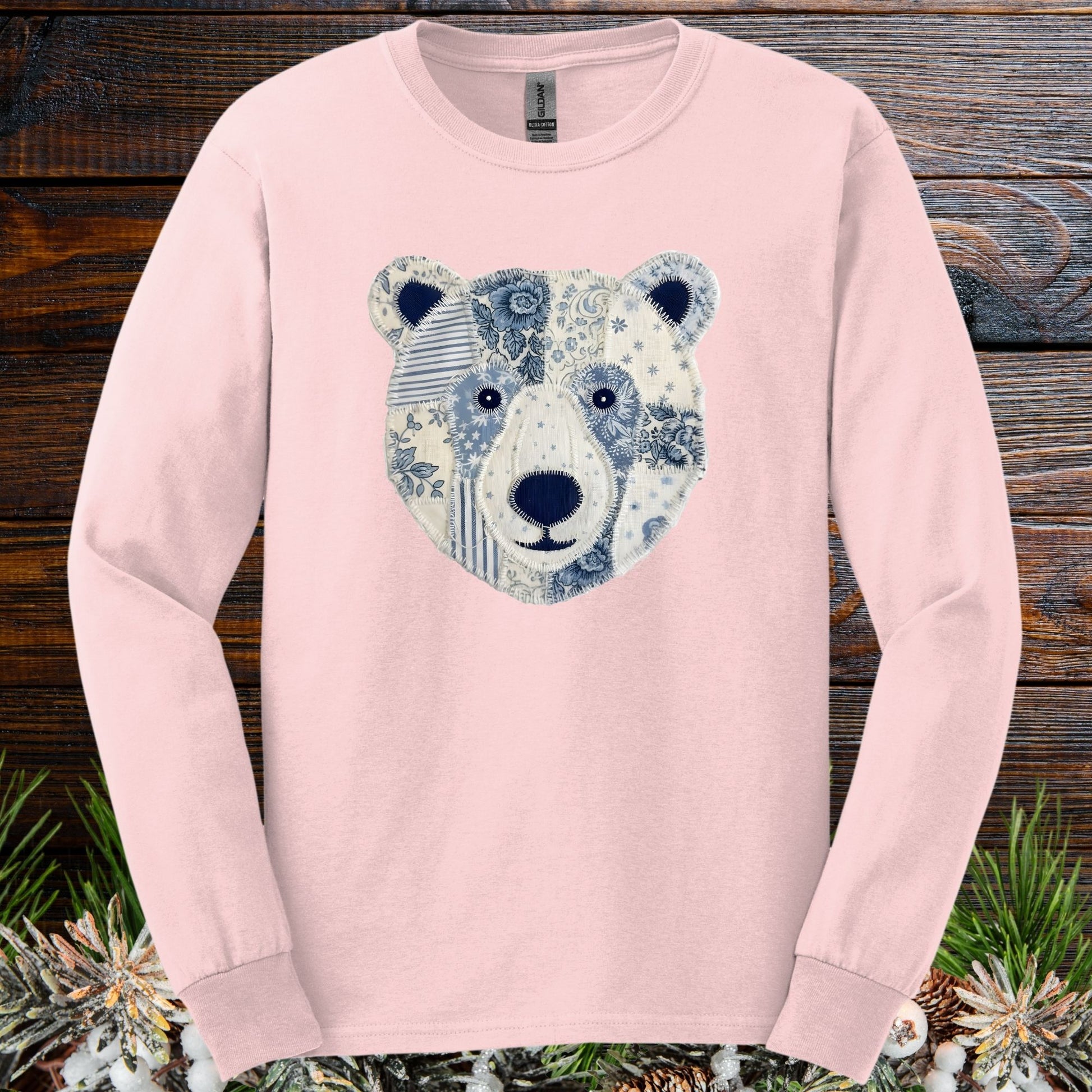 Light pink long sleeve tee with a faux patchwork blue and white winter bear face design.