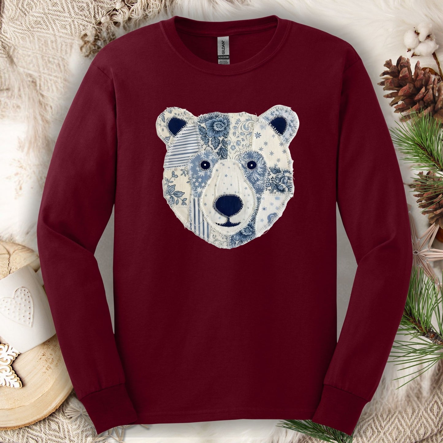 Maroon long-sleeve tee with a faux patchwork winter bear face design.