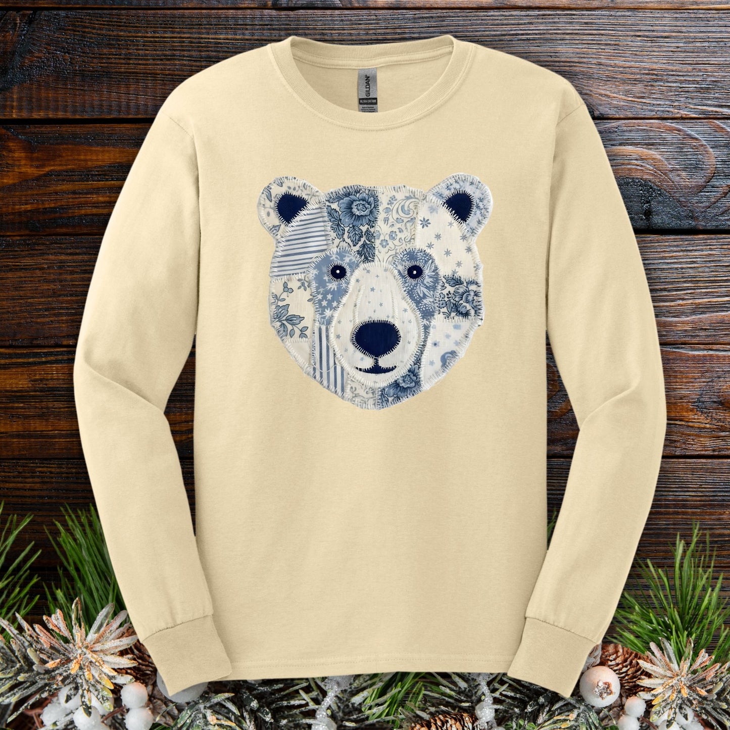 Sand long-sleeve tee with a faux patchwork blue and white winter bear face design.