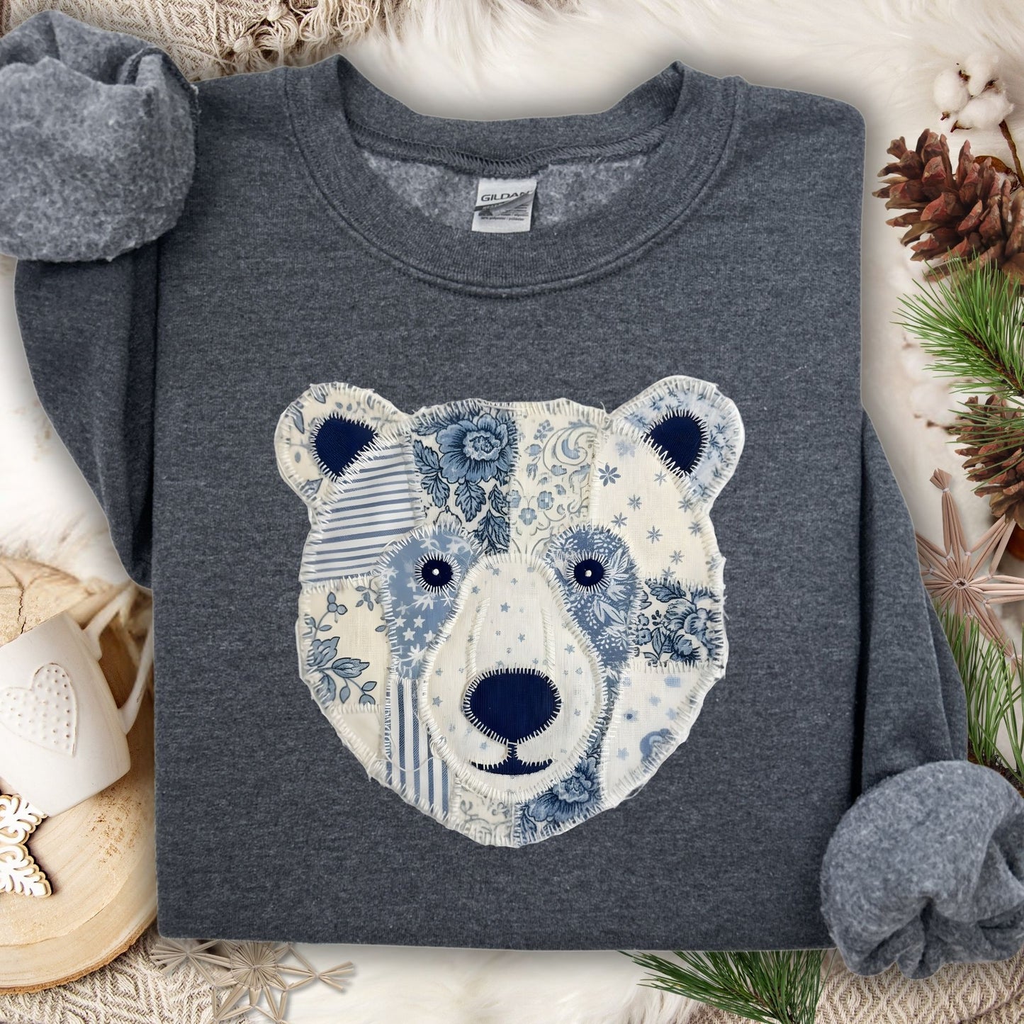 Dark heather sweatshirt with a faux patchwork blue and white country winter bear design.