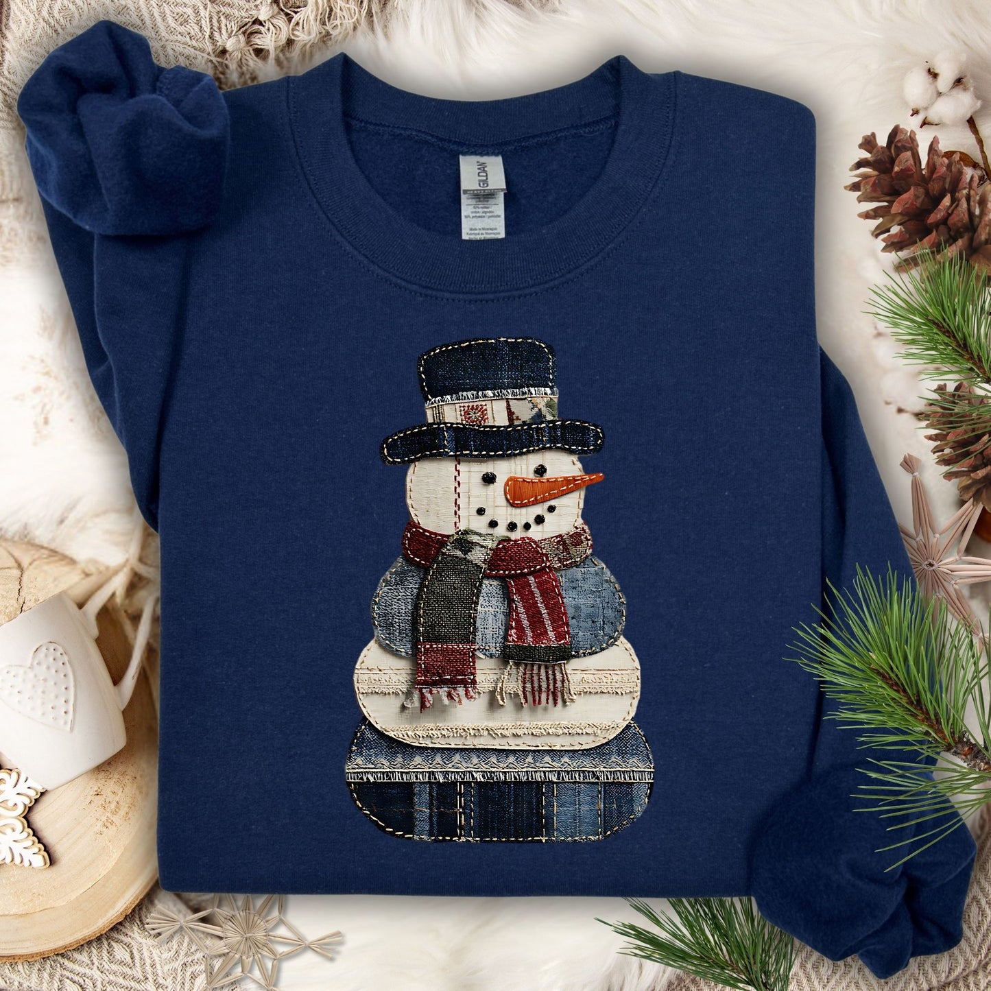Navy Gildan sweatshirt with a printed faux patchwork denim snowman design.