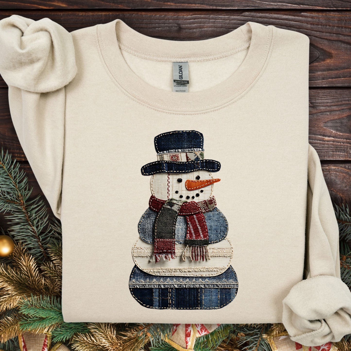 Sand Gildan sweatshirt with a faux patchwork denim snowman design.