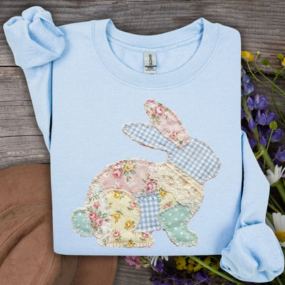Light blue Faux Patchwork Floral Bunny Sweatshirt with a pastel floral and gingham applique on a wooden background.