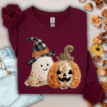 Maroon Gildan sweatshirt with faux patchwork ghost in witch hat and jack-o-lantern, surrounded by fall decor.