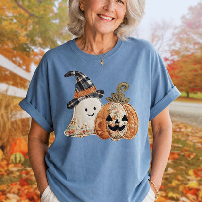 Woman in a blue Comfort Colors t-shirt with a faux patchwork ghost and jack o'lantern design.