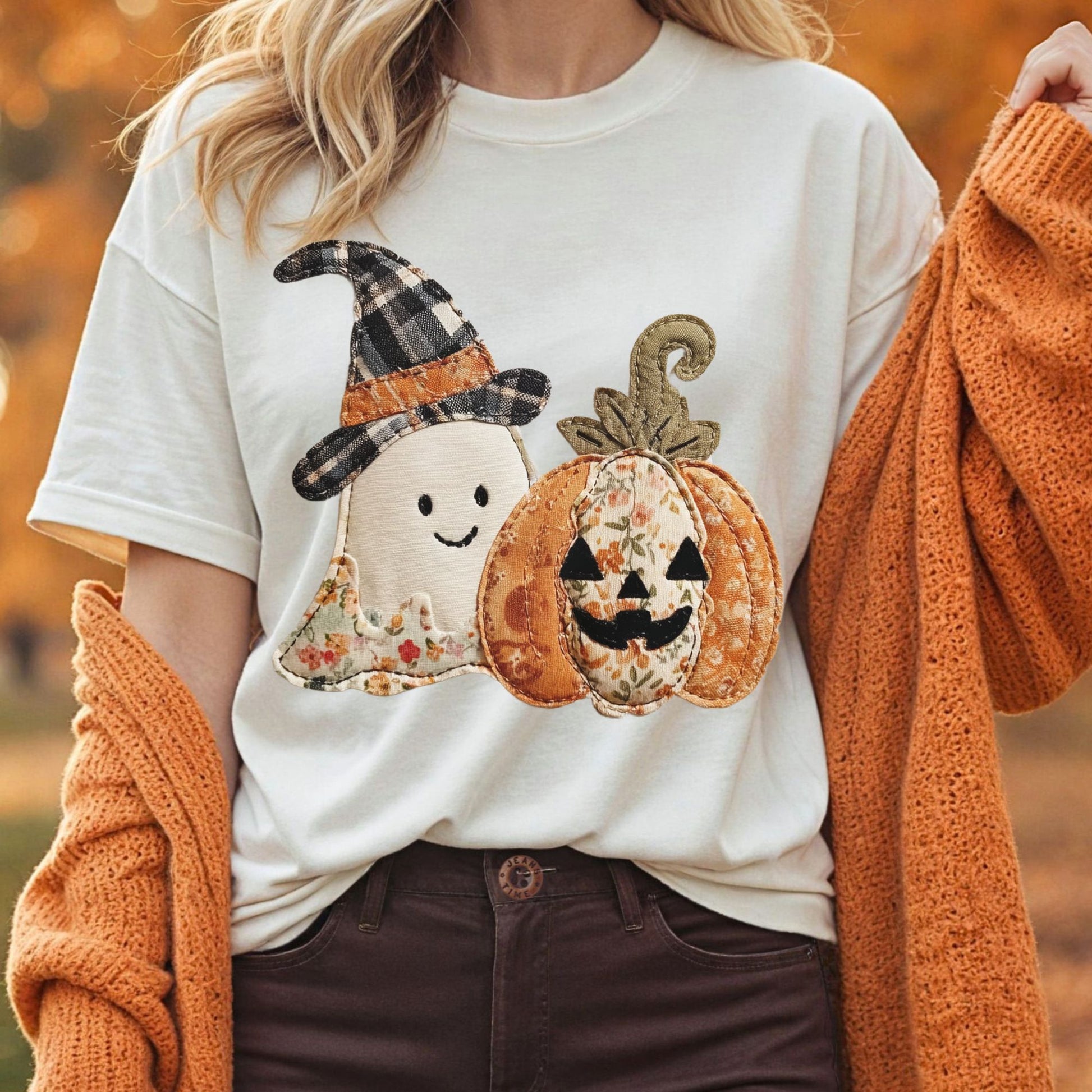 Comfort Colors Faux Patchwork Halloween Ghost & Jack O'Lantern T-Shirt in natural with an orange cardigan.