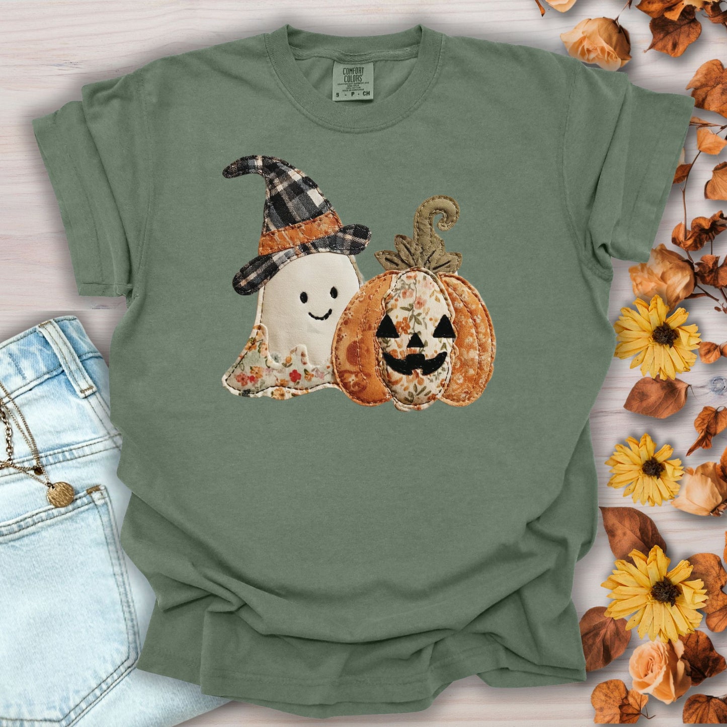 Moss green Comfort Colors t-shirt with a faux patchwork ghost and jack o'lantern design.