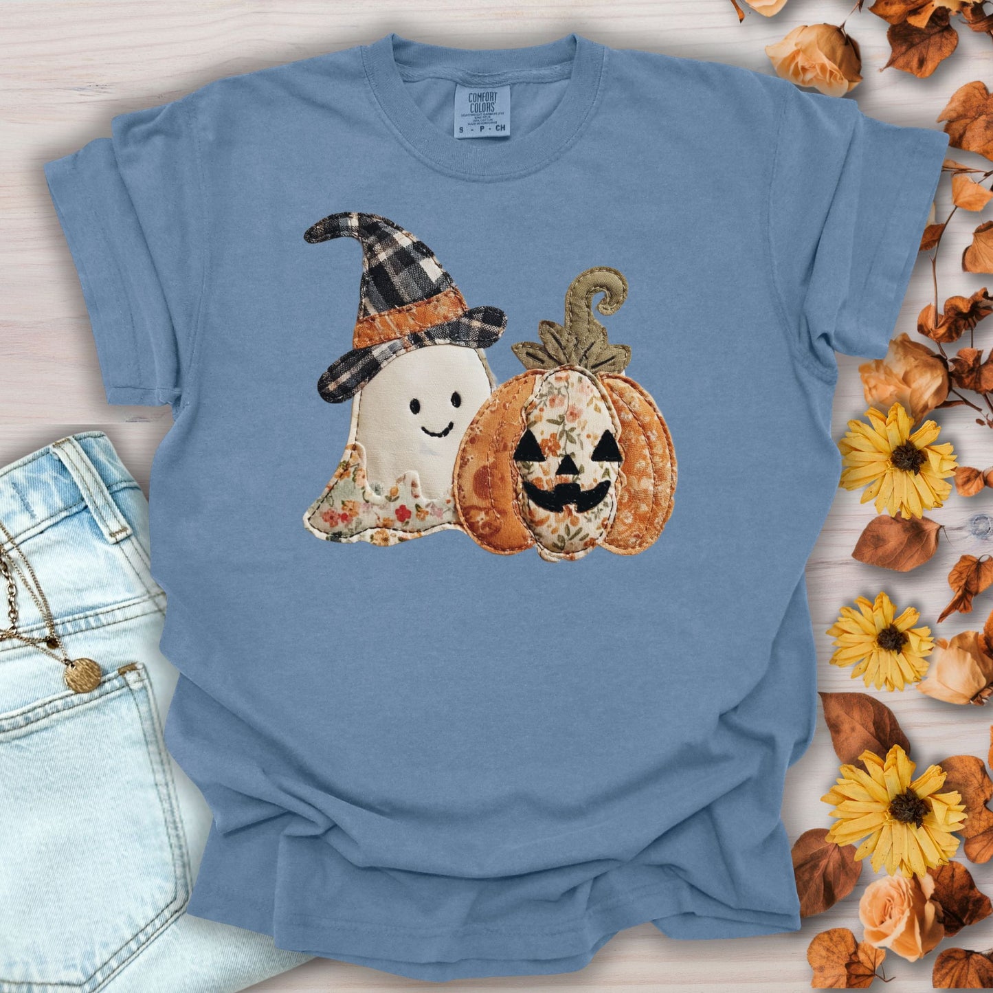 Blue Jean Comfort Colors t-shirt with a faux patchwork ghost in a plaid hat and a floral jack o'lantern.