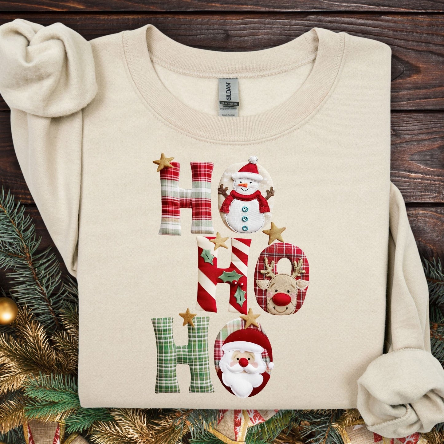 Sand Gildan sweatshirt with faux patchwork "Ho Ho Ho" design featuring Santa, Rudolph, and a snowman.