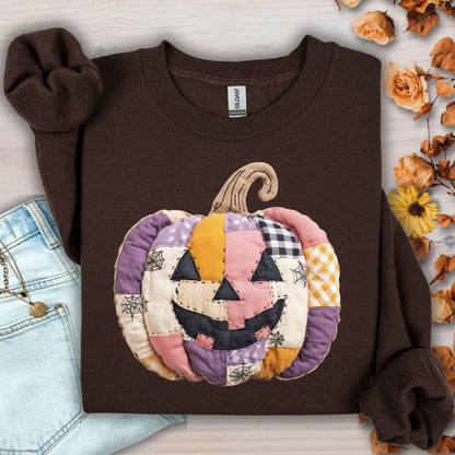 Dark Chocolate Gildan sweatshirt with a quilted patchwork jack-o-lantern in pink, purple, and yellow tones.