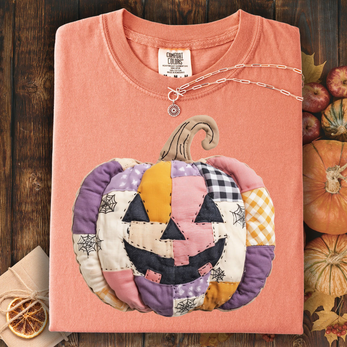 Faux patchwork jack-o'-lantern t-shirt in soft pink, purple, and orange cottage core tones.