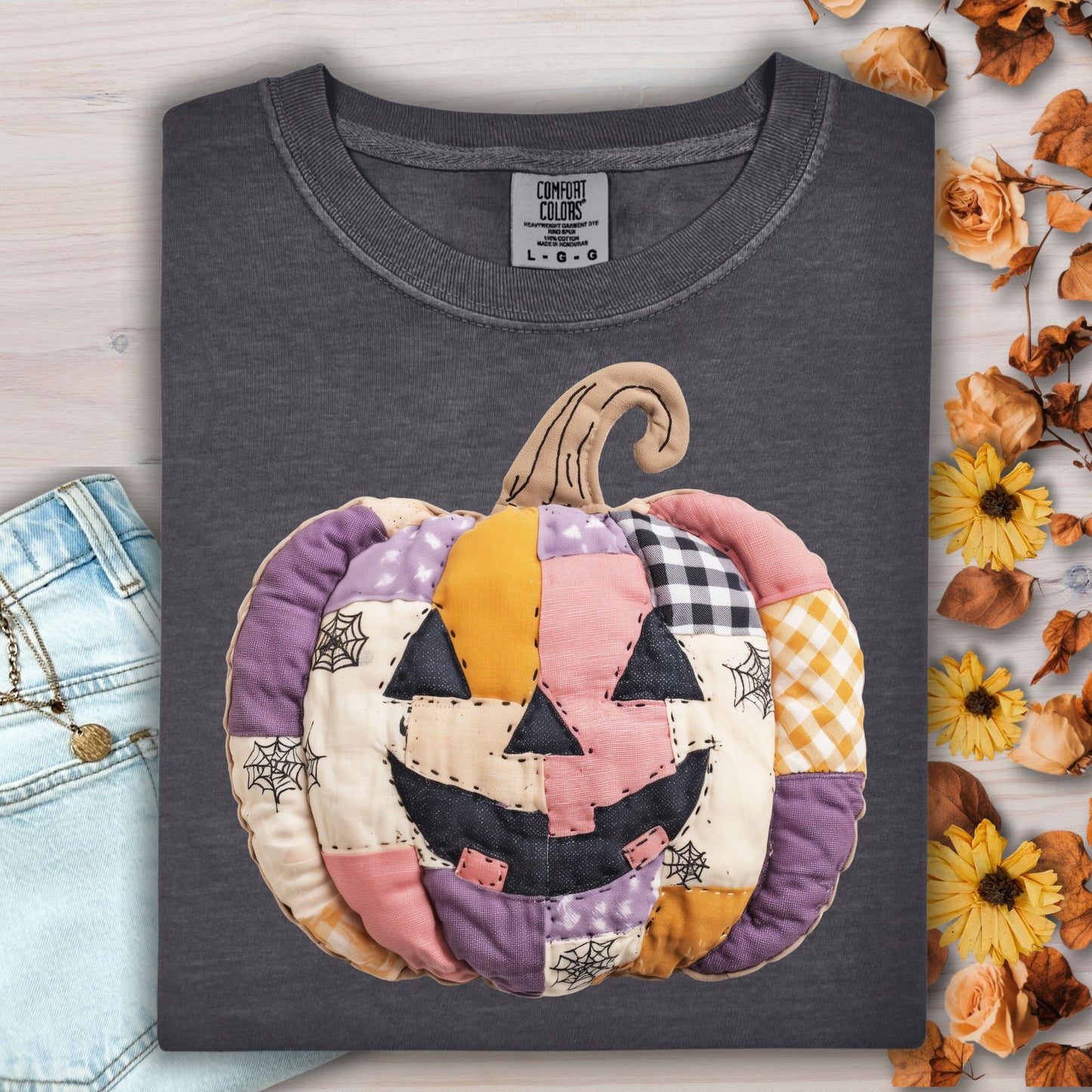 Pepper Comfort Colors tee with a faux patchwork jack-o'-lantern in pink, purple, and orange.