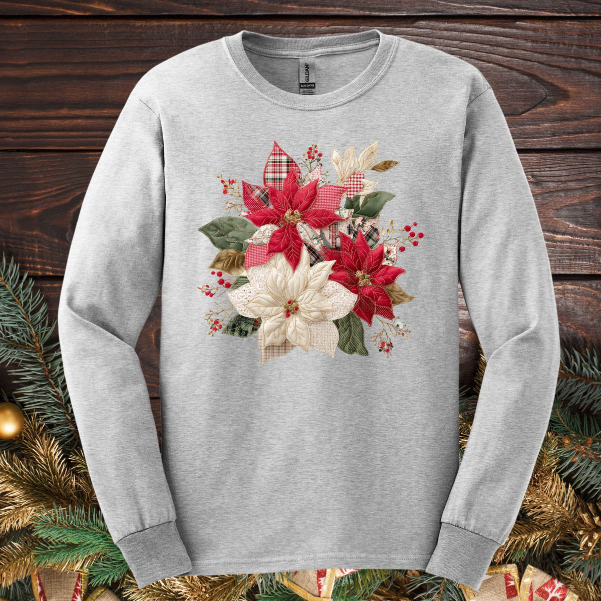 Ash long sleeve tee with a faux patchwork poinsettia design featuring red, white, gingham, and plaid fabrics.