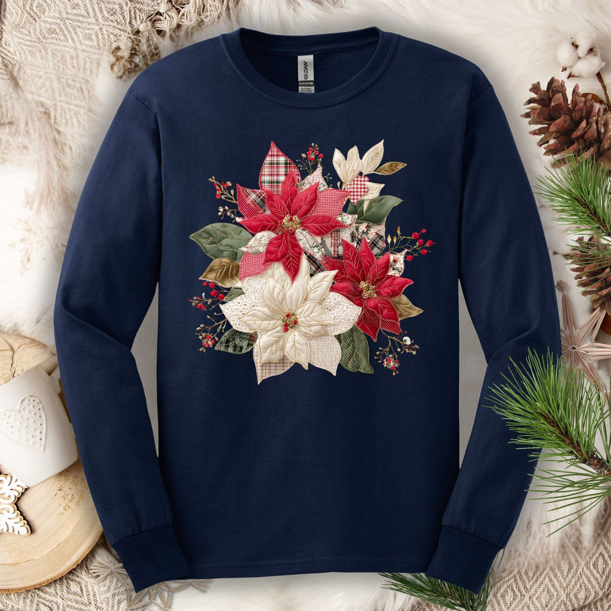 Navy long sleeve tee with a faux patchwork poinsettia design featuring red, cream, gingham, and plaid fabrics.