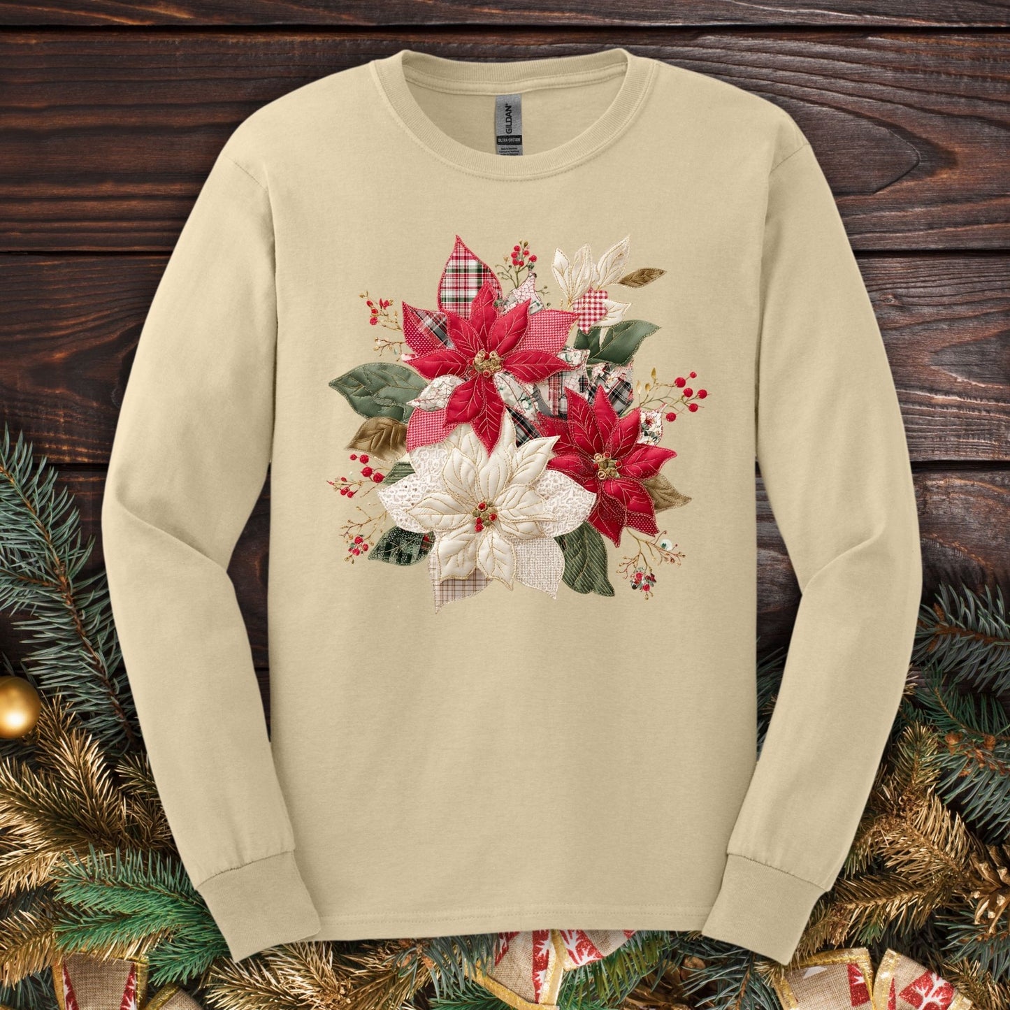 Sand long sleeve tee with a faux patchwork poinsettia design featuring red, white, gingham, and plaid details.