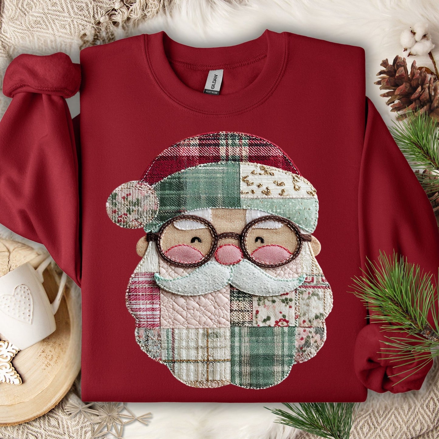 Cardinal Red Gildan sweatshirt with a printed faux patchwork smiling Santa, featuring soft Christmas tones.