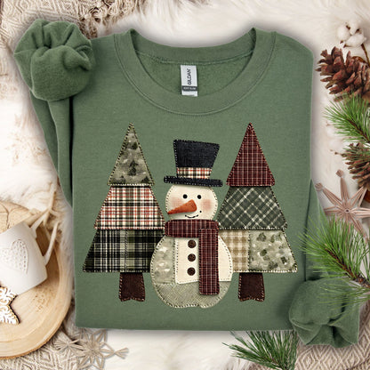 Military Green Gildan sweatshirt with a faux patchwork snowman and evergreen trees.
