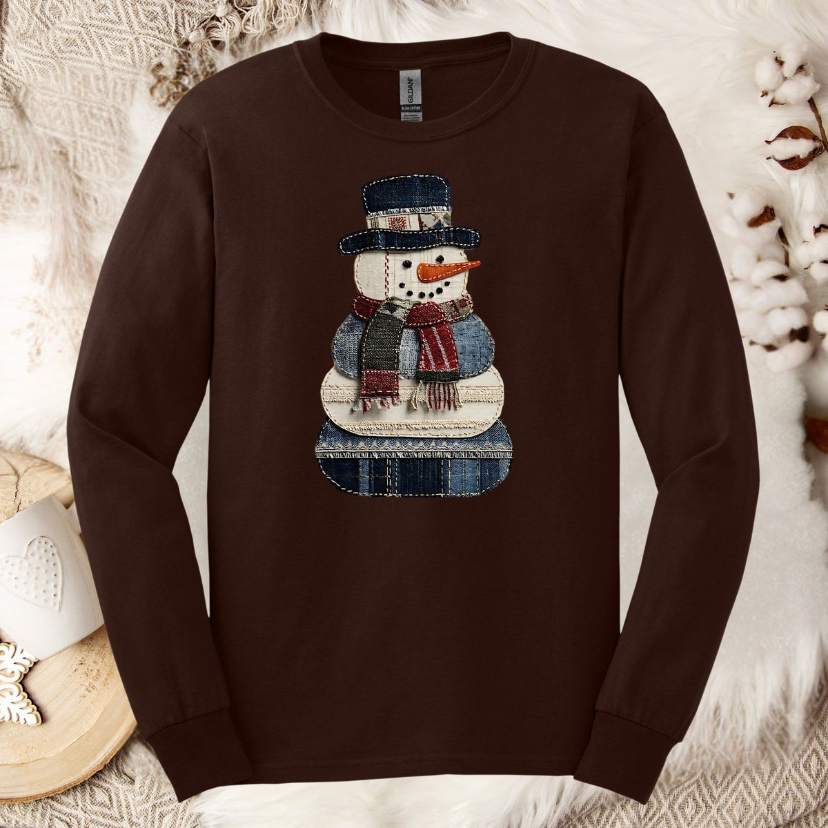 Dark chocolate long sleeve tee with a faux patchwork denim snowman and evergreen trees.