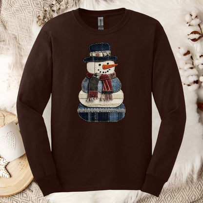Dark chocolate long sleeve tee with a faux patchwork denim snowman and evergreen trees.
