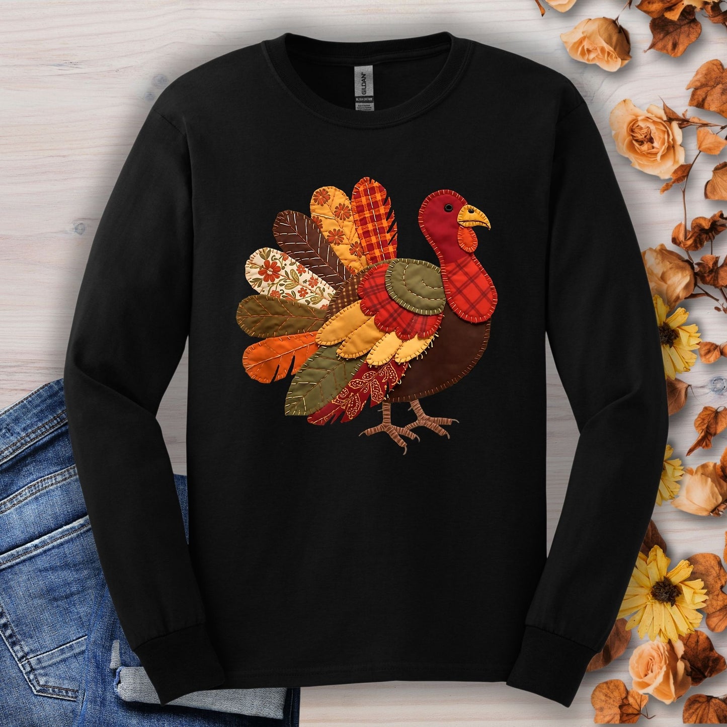 Black long sleeve tee with a colorful faux patchwork quilted turkey design in red, gold, brown, and forest green.