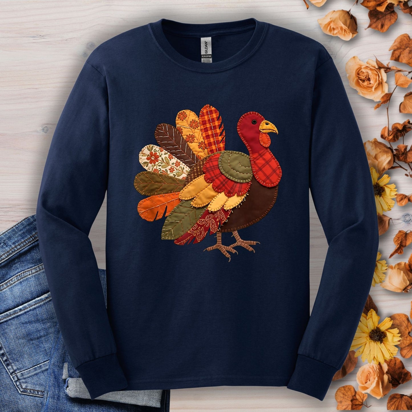 Navy long sleeve tee with a colorful faux patchwork Thanksgiving turkey design in fall hues.