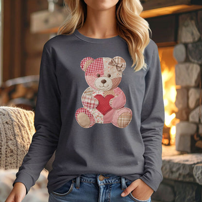 Woman wears a charcoal long-sleeve tee with a faux patchwork teddy bear holding a red heart.