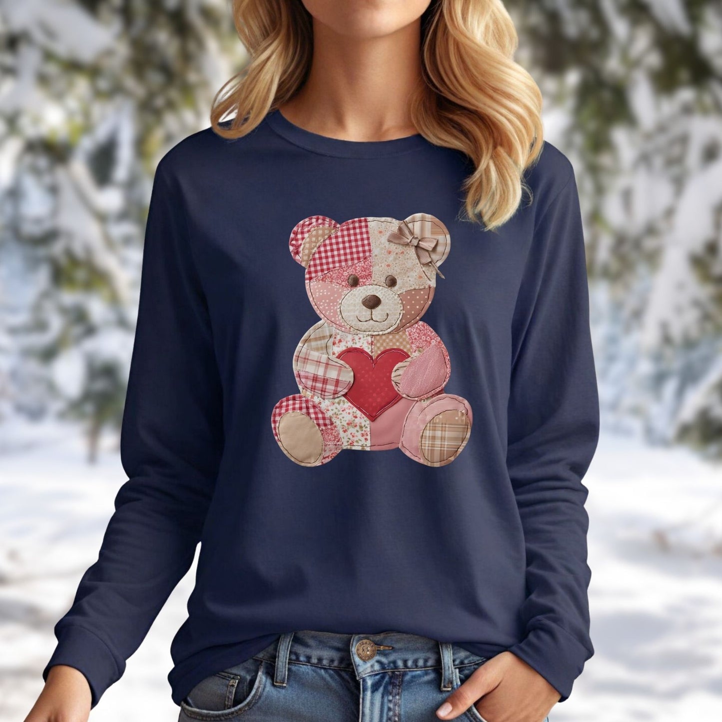 Navy long-sleeve tee with a faux patchwork teddy bear holding a red heart, worn by a woman.