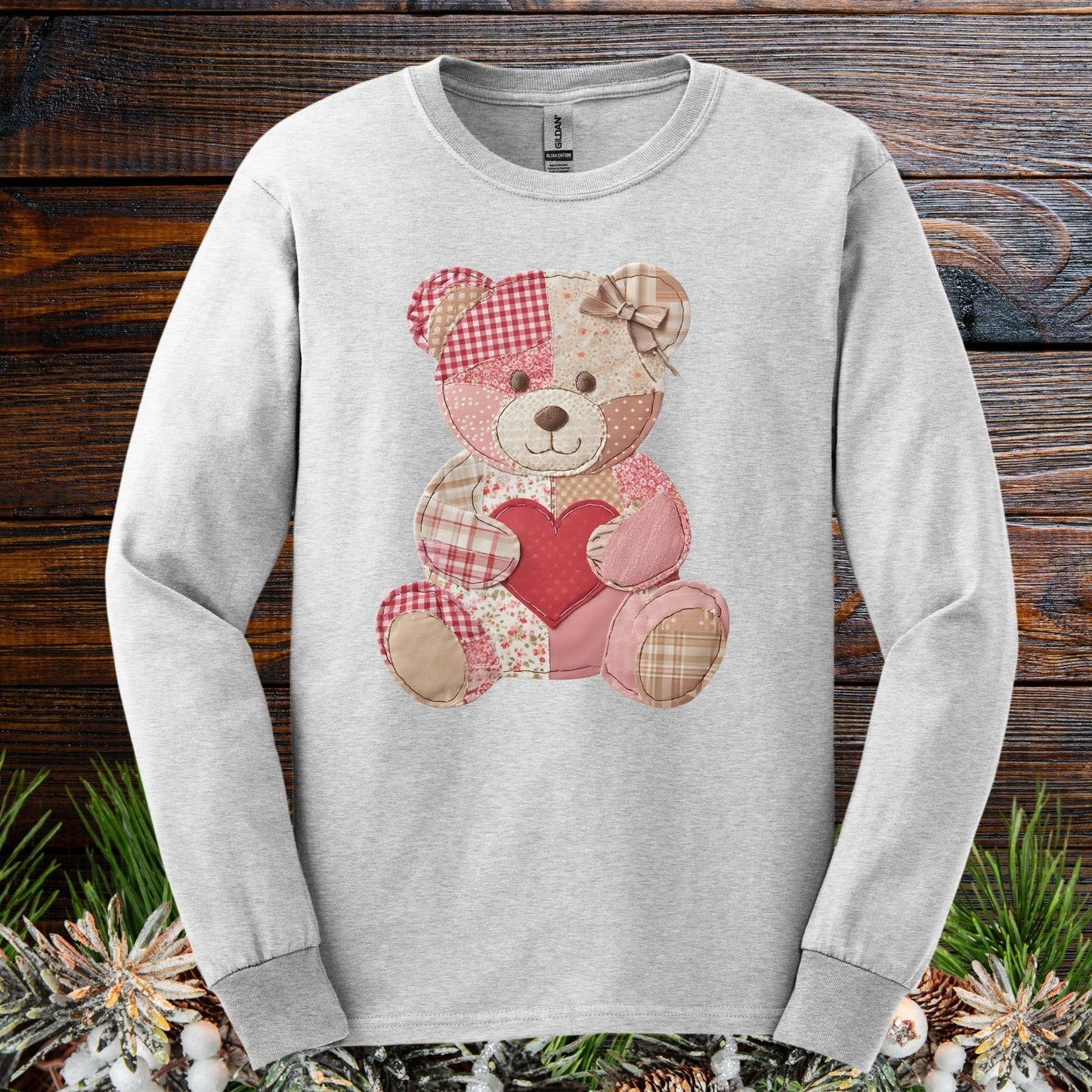 Ash long-sleeve tee with a faux patchwork teddy bear holding a red heart.