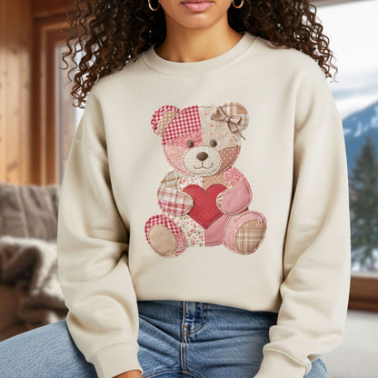 Cream unisex sweatshirt with a vintage faux patchwork teddy bear holding a red heart.
