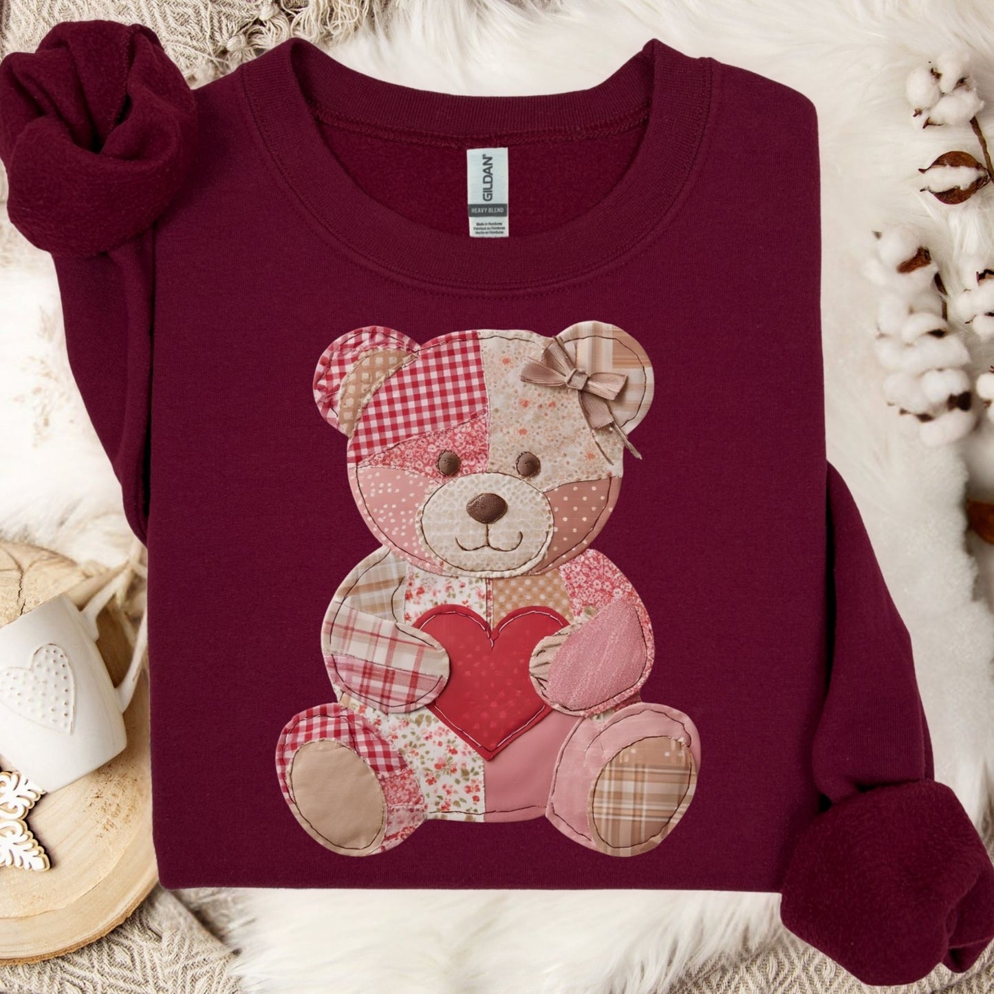 Maroon crewneck sweatshirt with a vintage patchwork teddy bear holding a red heart.