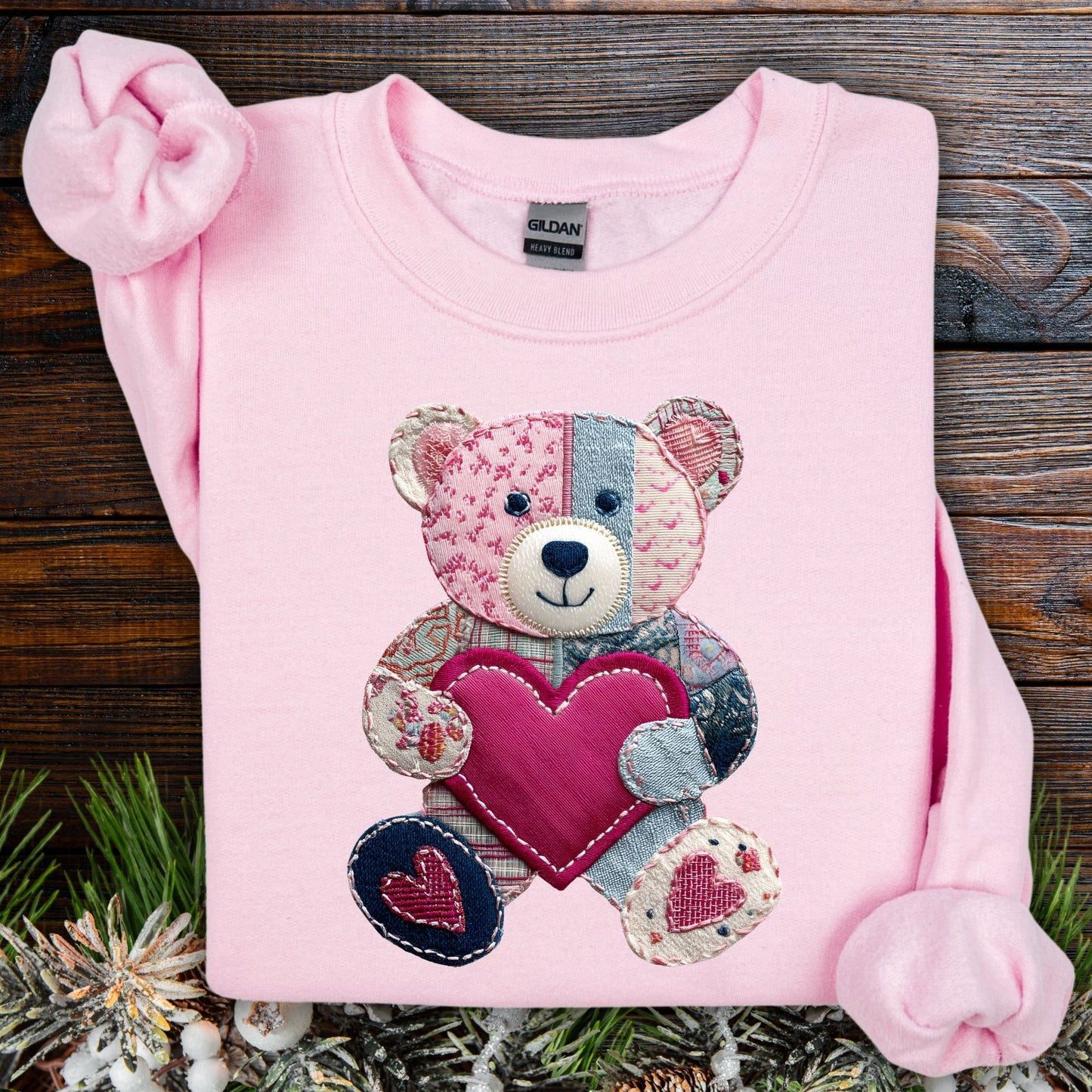 Light pink S sweatshirt with a printed faux patchwork teddy bear holding a pink heart.