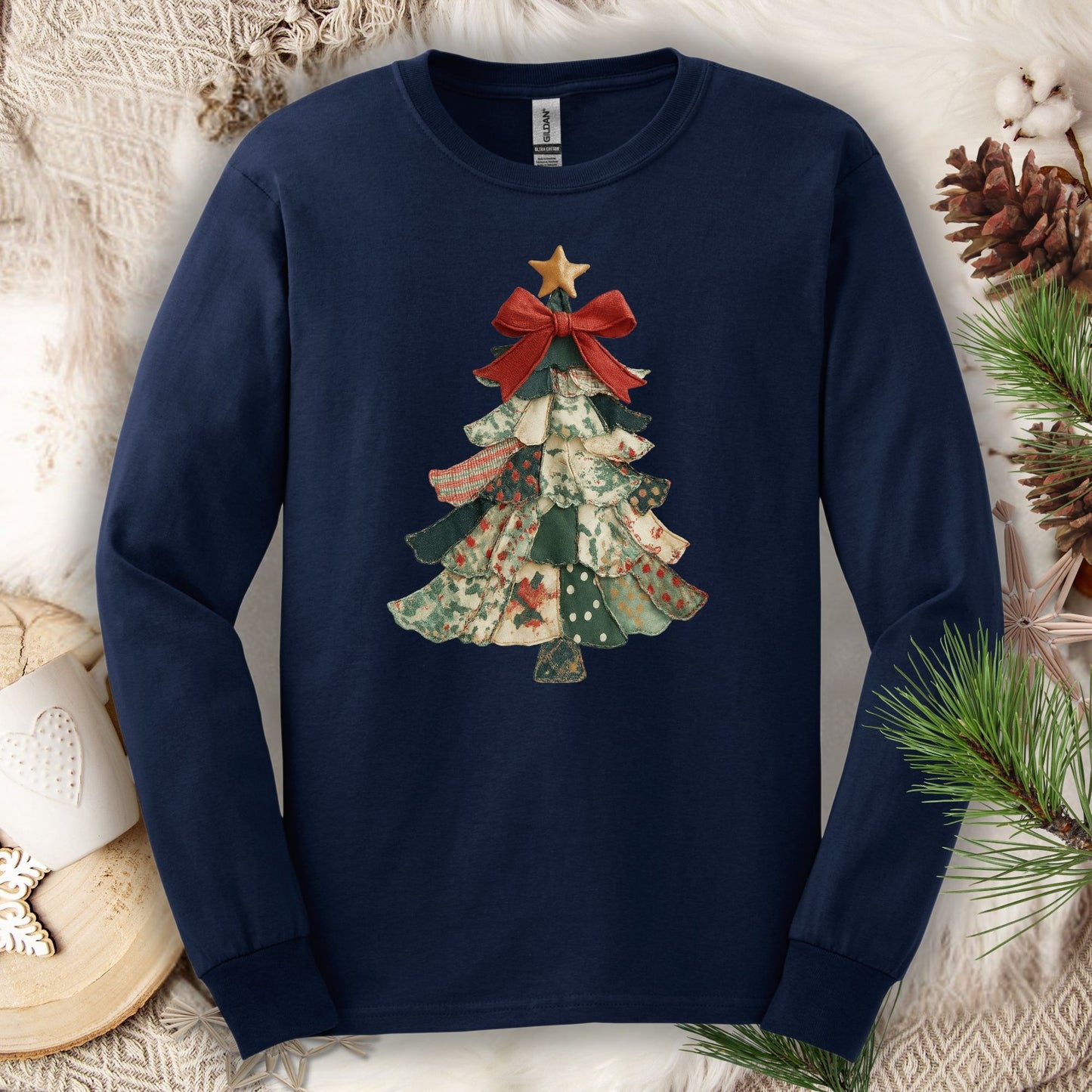 Navy long sleeve tee with a cottagecore patchwork Christmas tree design and red bow.