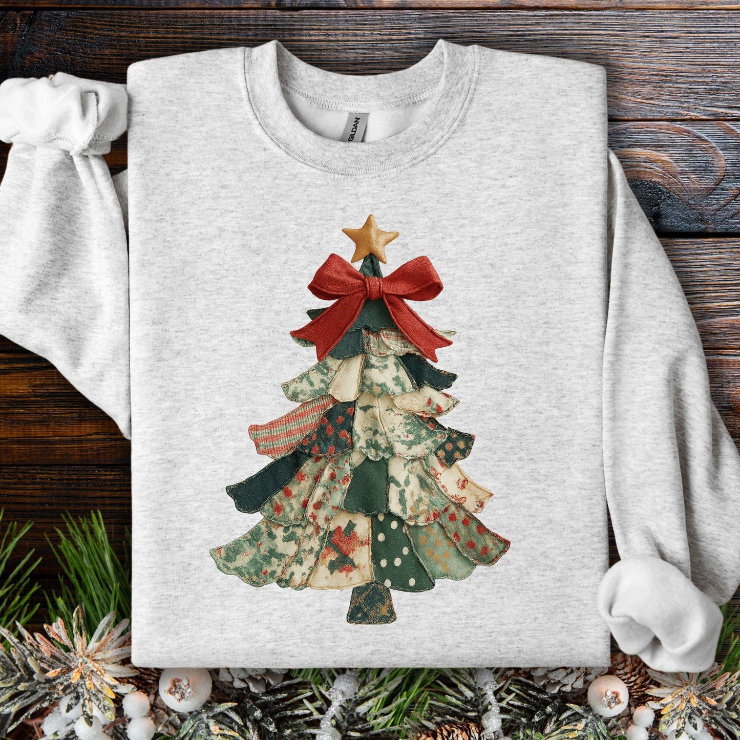 Ash gray sweatshirt with a vintage-inspired patchwork Christmas tree design, topped with a star and red bow.