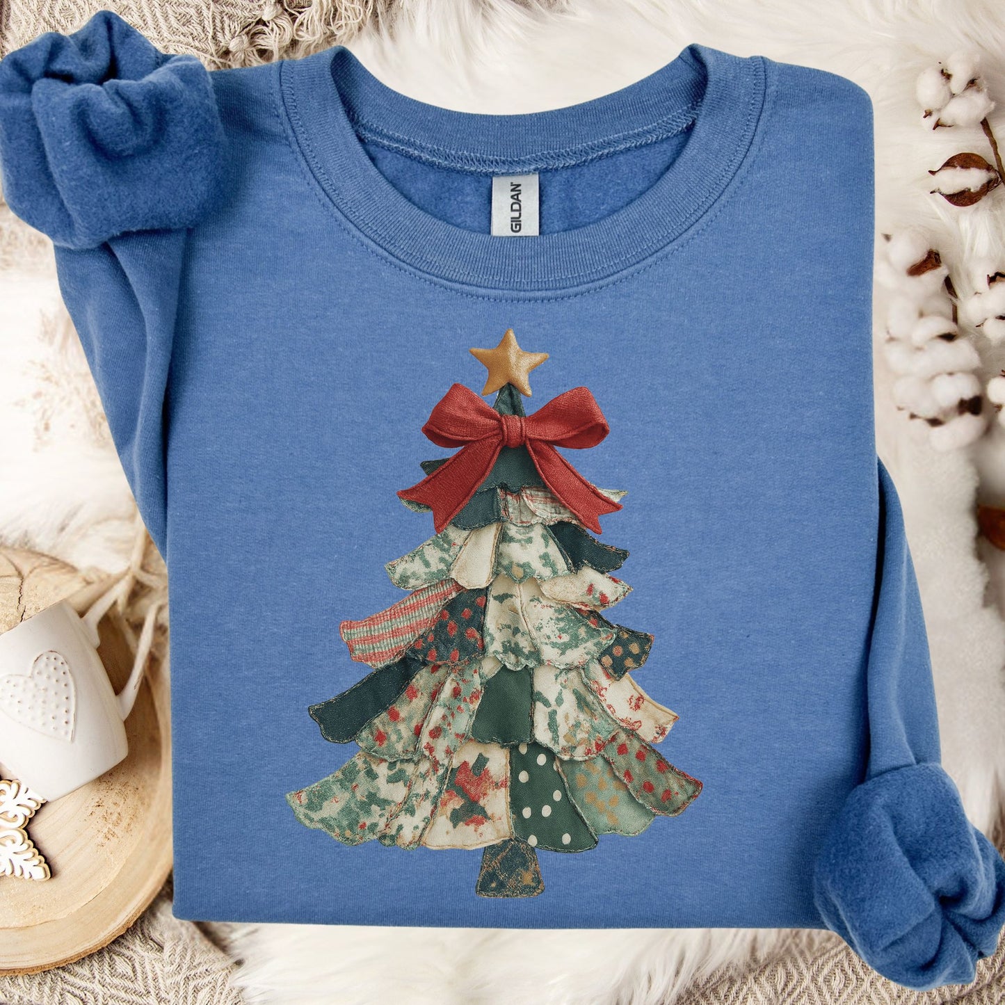 Indigo blue sweatshirt with a vintage-inspired patchwork Christmas tree design, featuring a red bow and gold star.