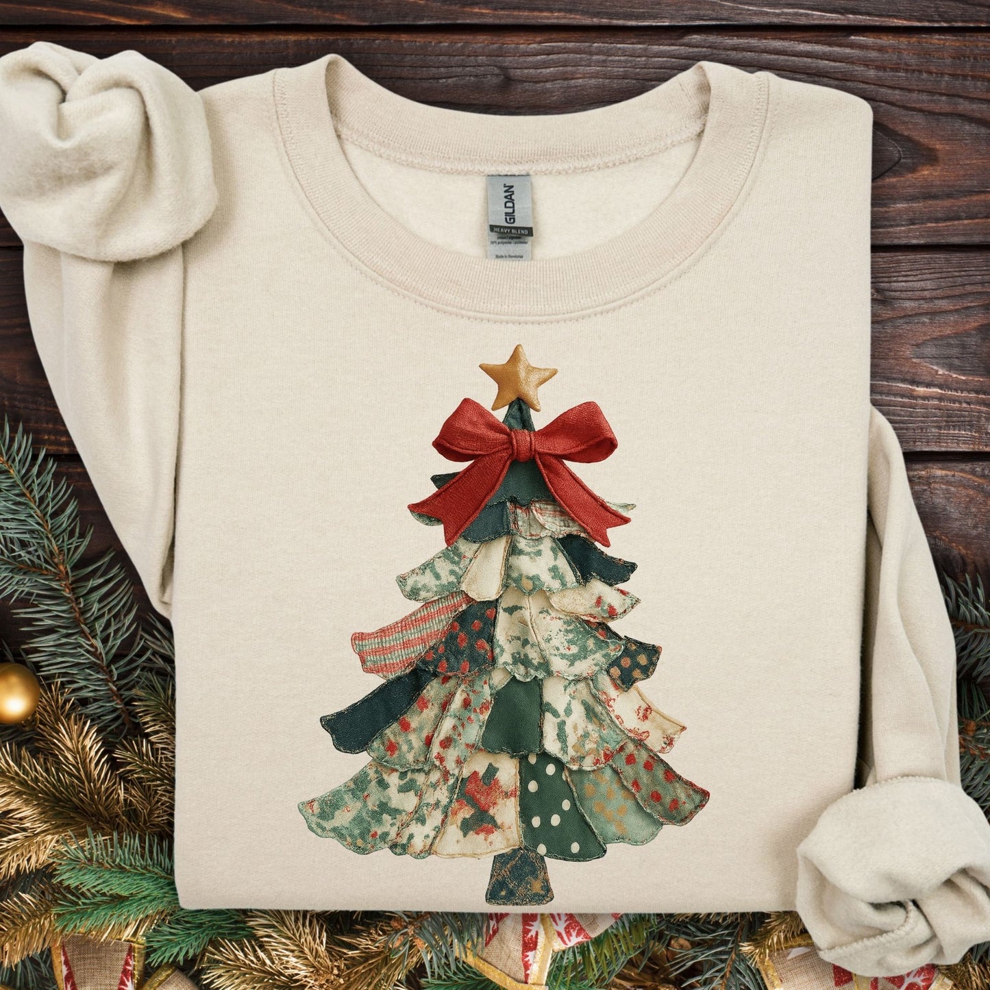 Sand S sweatshirt with a vintage-inspired patchwork Christmas tree design, red bow, and gold star.
