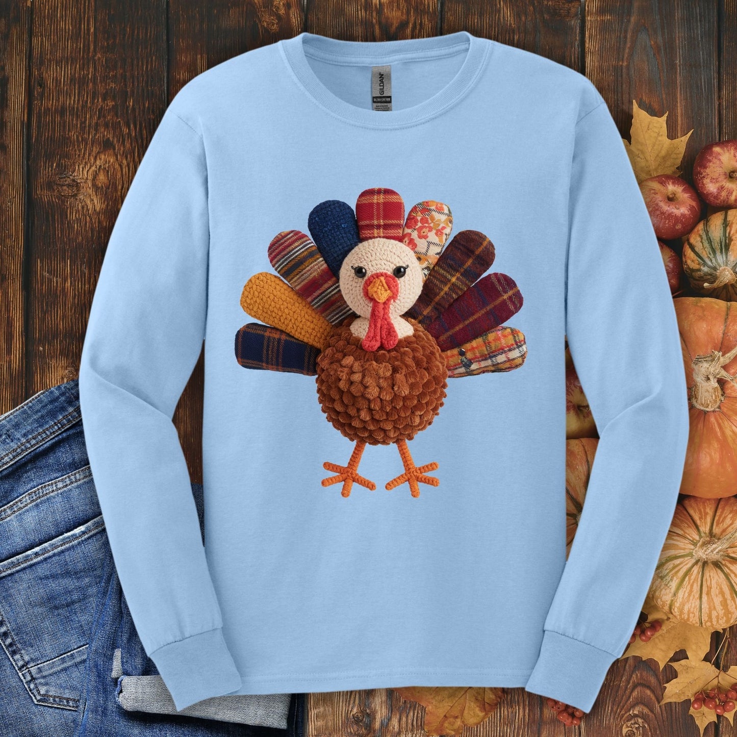 Light blue long sleeve tee with a faux patchwork turkey, hook yarn body, and vintage fall tones.