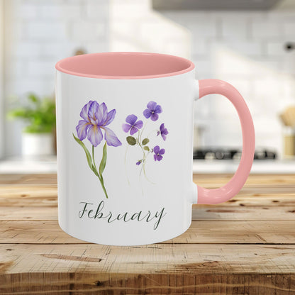 White 11oz ceramic mug with pink interior/handle, featuring watercolor purple iris and violet blooms, and "February" text.