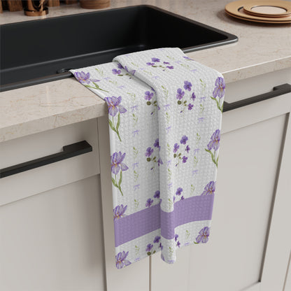 White microfiber tea towel with watercolor purple irises and violets, draped over a kitchen counter.