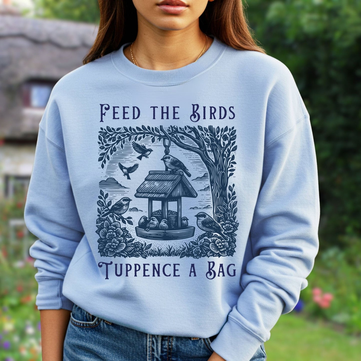 Light blue unisex crewneck sweatshirt with a vintage "Feed the Birds" illustration and text.