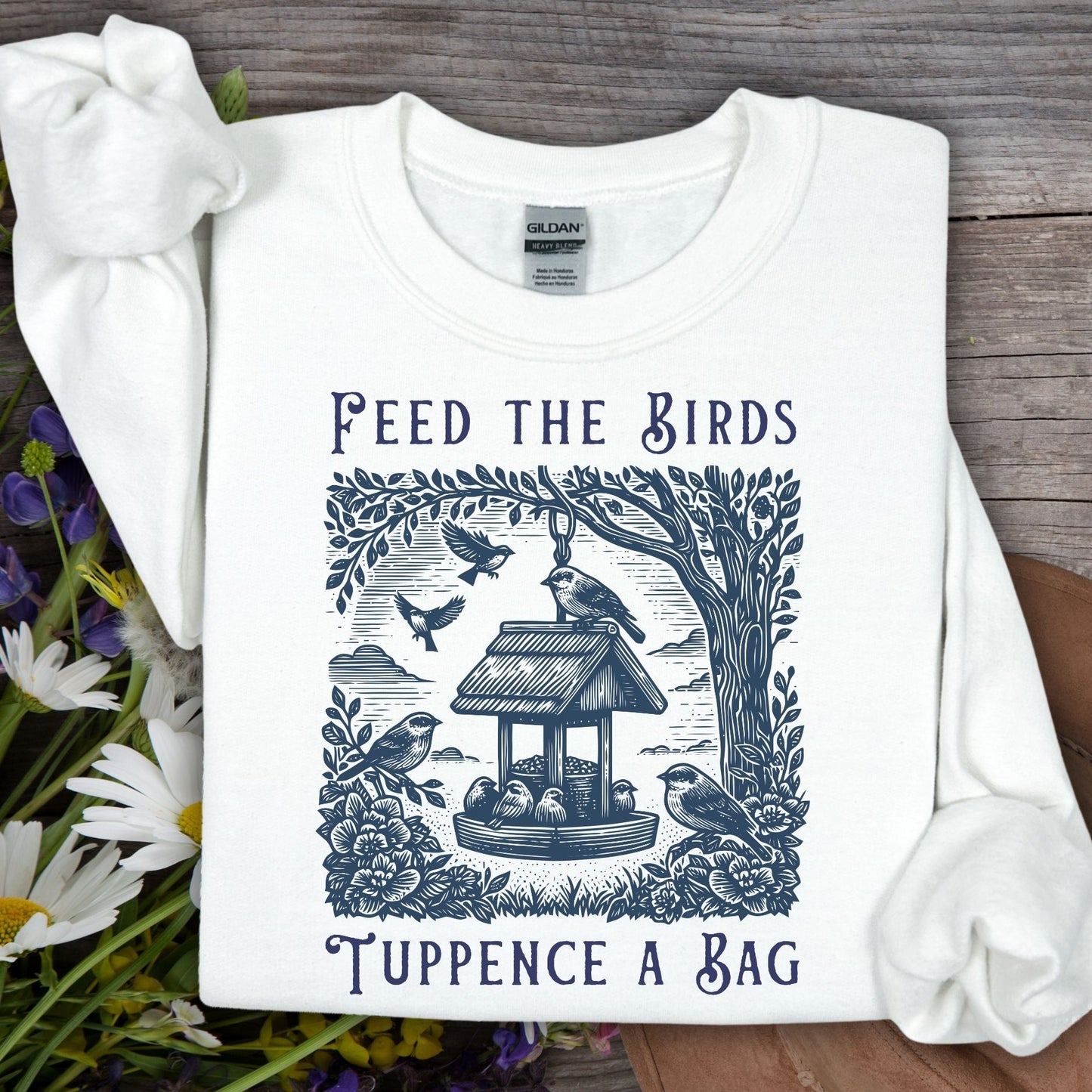White vintage crewneck sweatshirt with "Feed the Birds, Tuppence a Bag" text and bird feeder illustration.